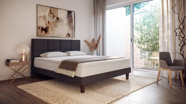 3D product rendering of an upholstered bed with a tall panelled headboard in a bedroom with terrace doors
